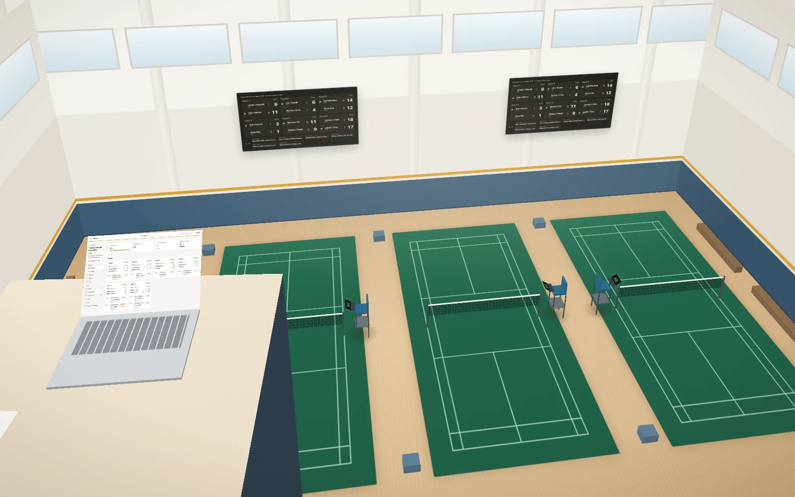 A sports hall set up with Roundr: badminton courts with a tablet at each umpire chair, screens on the wall and a desk with a laptop.